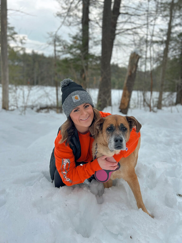 Woman with Dog in Snowy Forest