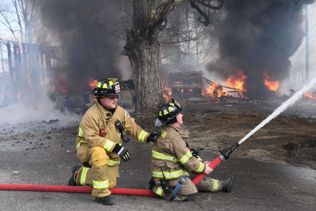 Two Firefighters Pumping Water at a Fire